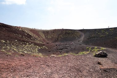 Tepesinde çok sayıda turist bulunan Etna Dağı 'nın küçük krateri ve merkezinde de taşlardan oluşan spiral. Etna volkanının ikincil boş krateri.