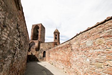 Şehrin çan kulelerine bakan tipik bir ortaçağ İtalyan köyünün duvarları üzerinde yol. Seyahat eden Umbria ve Toskana, İtalya
