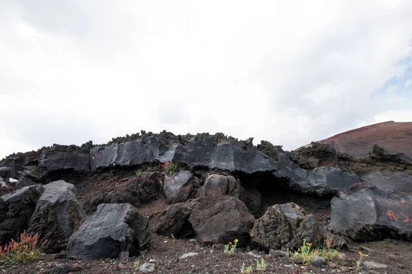 埃特纳山上 一个巨大的熔岩面慢慢冷却下来 光滑光滑的熔岩石 顶部有岩石 熔岩分裂 — 图库照片