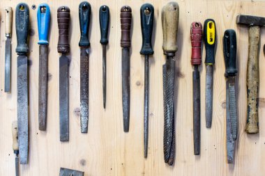 Marangoz aletleri seti. Ahşap teçhizat rafında bir sıra ahşap. Ahşap ya da metal atölyesi için öğütme raspaları