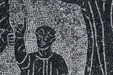 Roman mosaic with small black and white stones tiles representing a man with finger stand up. Detail of a mosaic in Ostia Antica, 2nd century. clipart
