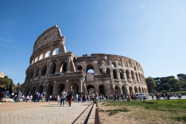 Roma 'da kolezyum, güneşli bir günde etrafını turistlerin sardığı toplam manzara.
