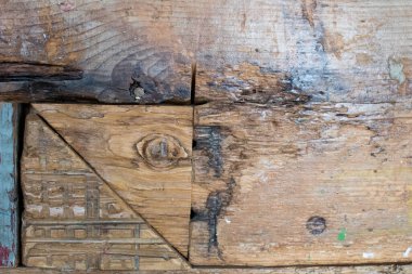 Birkaç geri dönüşümlü tahtadan yapılmış ahşap duvar. Farklı renkte tahtalar ve kesikler tek bir yapıda birleşmiş.