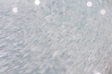 Sıvı bir sistemde dairesel dalga hareketi. Dairesel bir hareketin içine itilmiş bir sıvı için mavi gri arka plan. Soyut ve genel arkaplan olarak dalgalı dalgalar ve eş merkezli çemberler. hızlı dalgalanmalar