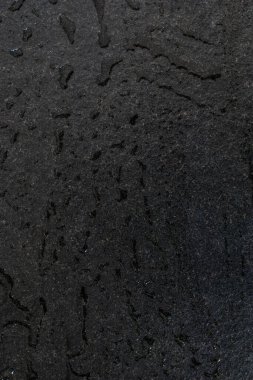Çiğ ve sert siyah granit levha suyla ıslanmış. Siyah granit bir levha üzerine su damlaları ve bantlar, döşeme ve yapı malzemelerinde tazelik ve zarafet. Siyah taş ve su damlaları.