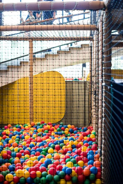 ball pool with a net for children. games for children in the amusement park, amusement area with a pool of colored soft balls, swimming in colored balls