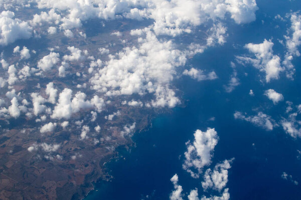 Белые облака с землей на заднем плане. воздушный вид на побережье с группами облаков, чтобы закрыть вид на местность. Вид с самолета
