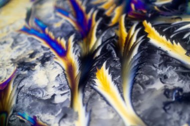 Donmuş su manzarasının arka planında polarize lensler, dallar, sivri uçlar ve beyaz üste çok renkli çizgiler var. Işığın gökkuşağı renkleri kristal gibi yansıyor ve çürüyor. Prizma olarak ışık kırılması