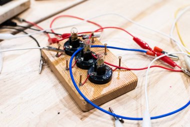 Düşük voltajlı çocuklarda elektrik devreleri. Timsah tokaları için bakır çivilerle ahşap tabanlara monte edilmiş. Okuldaki teknolojik eğitim aktiviteleri, BTMM ve elektronik aletler. Çocuk için kablolar ve devreler