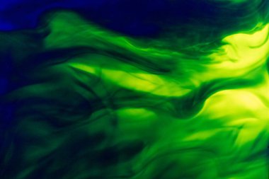 Bir sıvıda yeşil ve mavi mürekkep bulutu. Bulanık ve hareketli bir sıvıda renk dağılımı