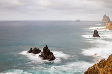 Kayalıklardan ve engebeli okyanuslardan görünen kayalar ve deniz manzarası. Baharda Tenerife Adası