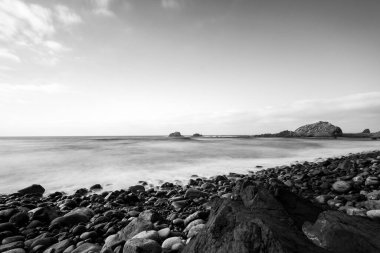 Deniz manzarası, günbatımında sahilin deniz manzarası, deniz, dağlar, kayalar, bulutlar ve yumuşak ışık dalgaları. Gün batımında Tenerife adası kıyısı ve denizi