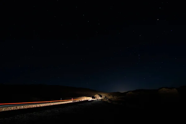特内里费的Teide火山的夜间照片 夜晚星空的映像 城市的光芒闪耀在地平线上 轻盈的小径映衬着一辆汽车 — 图库照片