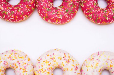 Beyaz arka planda pembe ve beyaz donutlar..