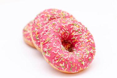 Beyaz arka planda renkli serpiştirilmiş pembe donutlar..