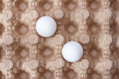 Kağıt tepside iki beyaz tavuk yumurtası..