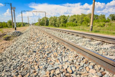 Kırsal bölgelerdeki demiryolu rayları, ormandan geçiyor. Bulutlu güzel bir gökyüzü. Sibirya şehir manzarası.