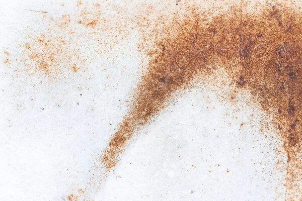 A close-up of rust on a white metal plate. Abstract background texture.