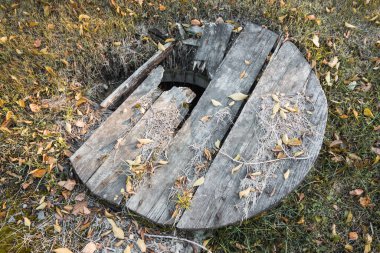 Eski terk edilmiş kuyu, kırık ahşap kapaklı..