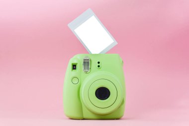 Yeşil hazır kamera ve pembe arka planda hazır çekilmiş fotoğraflar. Model