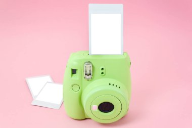 Yeşil hazır kamera ve pembe arka planda hazır çekilmiş fotoğraflar. Model.