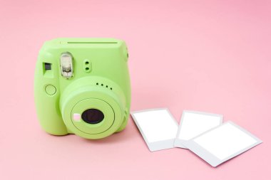 Yeşil hazır kamera ve pembe arka planda hazır çekilmiş fotoğraflar. Model.
