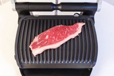 Bir parça taze et. Elektrikli ızgarada etli biftek..