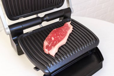 Bir parça taze et. Elektrikli ızgarada etli biftek..