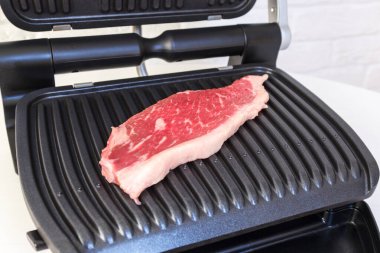 Bir parça taze et. Elektrikli ızgarada etli biftek..