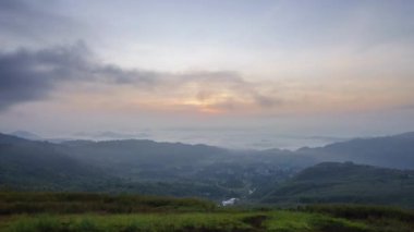 Güzel altın gün doğumu hızlı bulutlar köyün üzerinde sürükleniyor. RANAU, SABAH, BORNEO 'da çekildi.