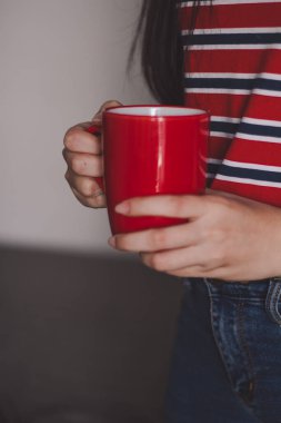 Kırmızı kahve bardağını tutan kadın yaklaşıyor. Sabah kahve ya da süt iç.. 