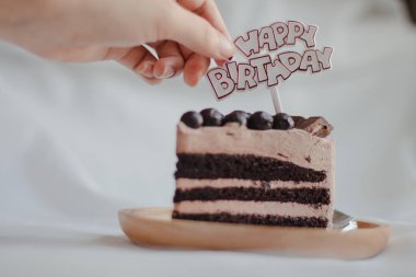 Yakın plan kadın doğum günü kutlaması için pasta hazırlıyor. Bir parça çikolatalı pasta..