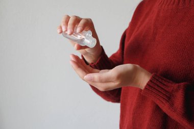 Kadın ellerini çamaşır deterjanıyla Coronavirus veya Covid-19 virüslerine karşı kapatın. Sağlık sigortası konsepti. Kırmızı kazak.