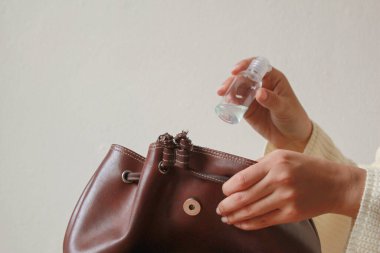 Kadın deri çantaya alkol jeli dezenfektanı koymuş..