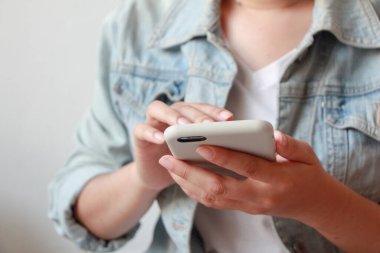 Akıllı telefon kullanan genç bir kadın..