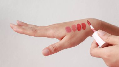Beyaz arka planda kadın eli üzerinde ruj izleri..