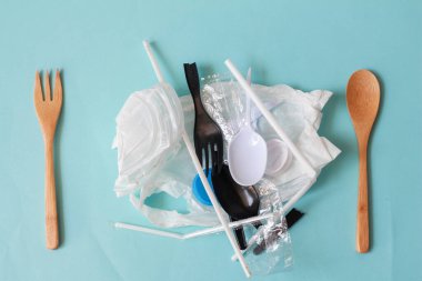 Plastik atıklarla çatal ve kaşık. Plastik atıklarla çevre kirliliği kavramı. Besin içinde mikroplastik.