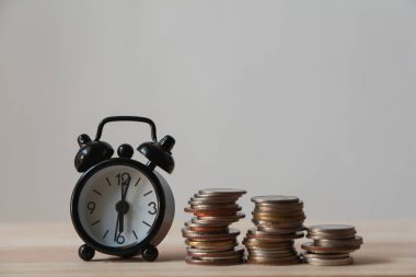 Para yığını ve çalar saat ahşap masa üzerinde. İş dünyası finansal fikirleri kavramı. 