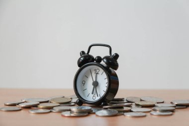 Para yığını ve çalar saat ahşap masa üzerinde. İş dünyası finansal fikirleri kavramı.. 