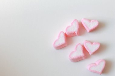Beyaz arkaplanda kopyalama alanı olan pembe kalp şekerlemesi.
