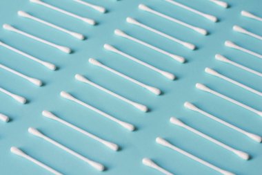 Mavi arkaplanda beyaz pamuklu çubuklar. 