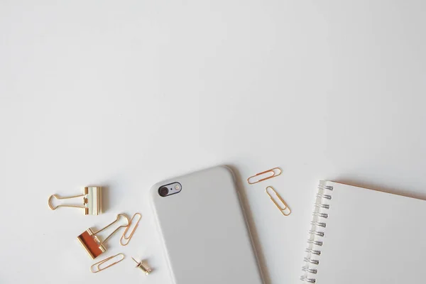 notebook,smartphone,paper clip and pen on white background,Top view.