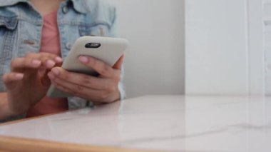 Masada akıllı telefon kullanan genç bir kadın. İş kadını cep telefonuna mesaj yazıyor..