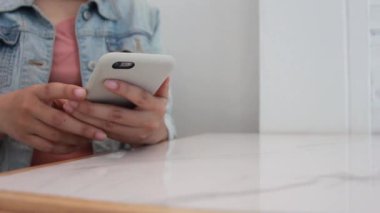 Masada akıllı telefon kullanan genç bir kadın. İş kadını cep telefonuna mesaj yazıyor..