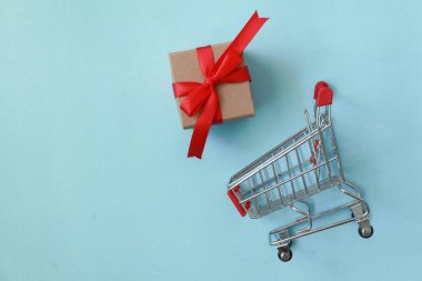 Beyaz arka planda minyatür alışveriş arabasının hediye kutusu. Noel ve mutlu yıllar konsepti.