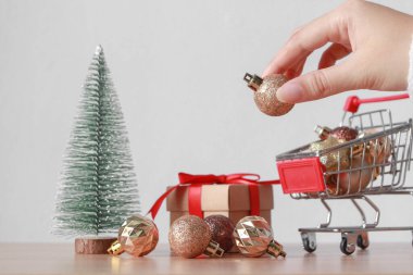 Beyaz bir arka planda, parlak Noel süslerini alışveriş arabasına koymak. Noel alışverişi konsepti.
