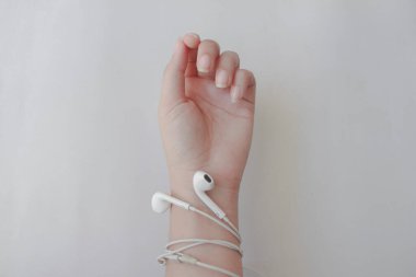 Beyaz arka planda kulaklığı olan bir kadın eli. Müzik benim hayatım..