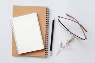 Not defteri, kağıt, kalem ve gözlüklerle beyaz arkaplan üzerinde düz kırtasiye, en az çalışma alanı.