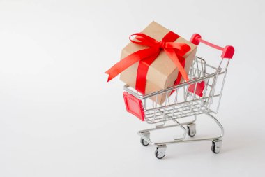 Beyaz arka planda minyatür alışveriş arabasının hediye kutusu. Noel ve mutlu yıllar konsepti.