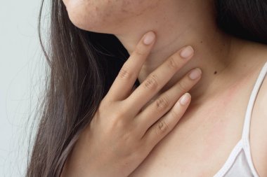 Tiroid bezini tek başına kontrol eden bir kadın. Ya da boğaz ağrısı veya boyun ağrısı..